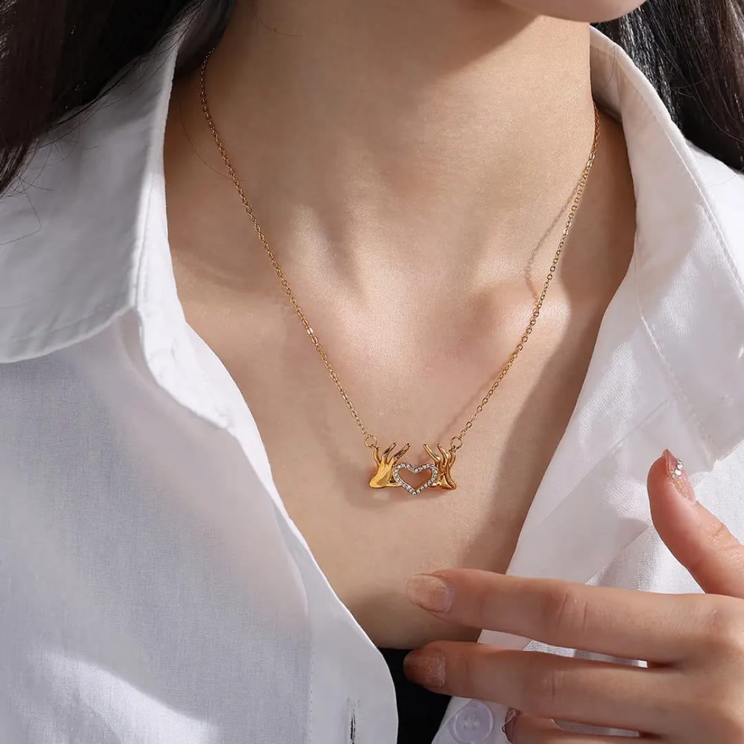 Hand holding heart pendant and chain 18k gold plated jewellery