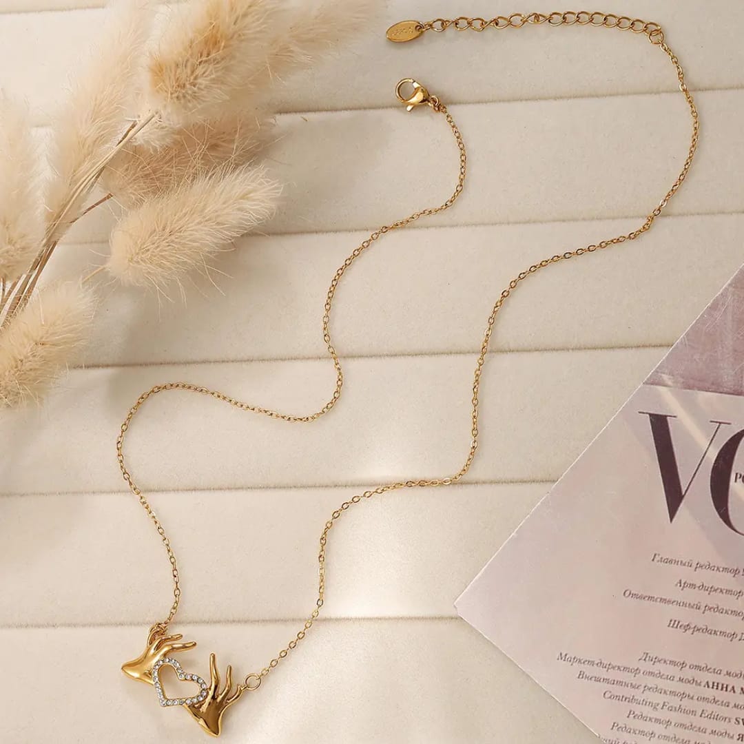 Hand holding heart pendant and chain  18k gold plated jewellery