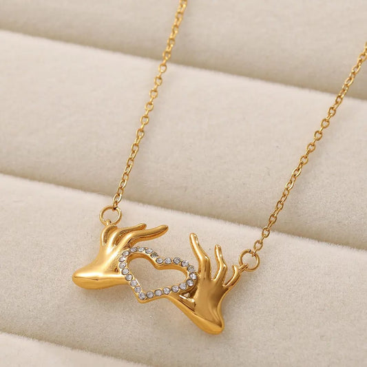 Hand holding heart pendant and chain  18k gold plated jewellery